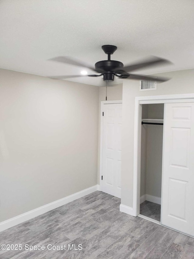 5600 N Banana River Blvd Unit 38, Cocoa Beach, FL 32931 - unfurnished bedroom with a closet, wood finished floors, and ceiling fan