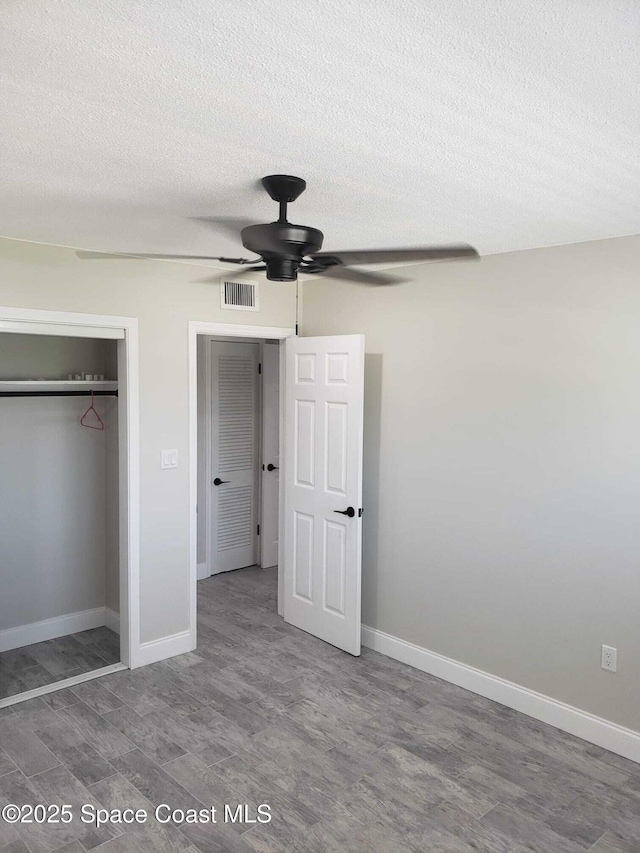 5600 N Banana River Blvd Unit 38, Cocoa Beach, FL 32931 - unfurnished bedroom with wood finished floors, a closet, a textured ceiling, and ceiling fan