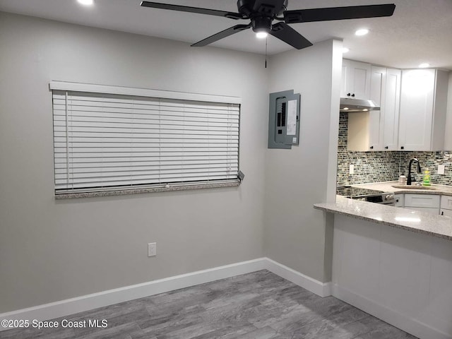 5600 N Banana River Blvd Unit 38, Cocoa Beach, FL 32931 - kitchen with a ceiling fan, under cabinet range hood, electric panel, light wood finished floors, and white cabinetry