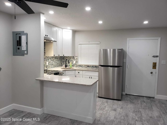 5600 N Banana River Blvd Unit 38, Cocoa Beach, FL 32931 - kitchen with freestanding refrigerator, electric panel, a ceiling fan, white cabinetry, and under cabinet range hood