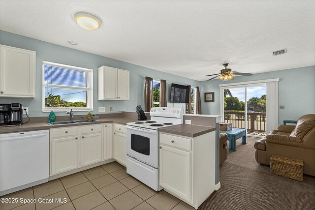 105 Ocean View Ln, Melbourne, FL 32903 - kitchen with white appliances, open floor plan, a peninsula, and white cabinets