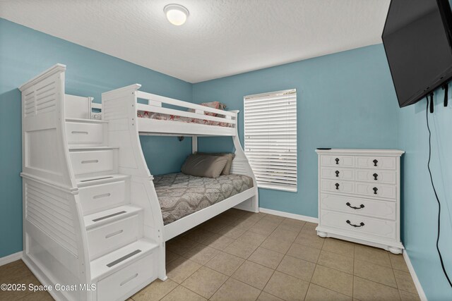 105 Ocean View Ln, Melbourne, FL 32903 - bedroom featuring a textured ceiling and light tile patterned flooring
