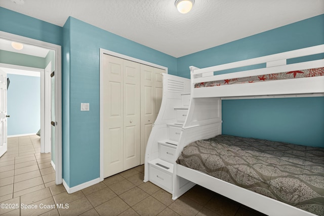 105 Ocean View Ln, Melbourne, FL 32903 - unfurnished bedroom with tile patterned floors, a closet, and a textured ceiling