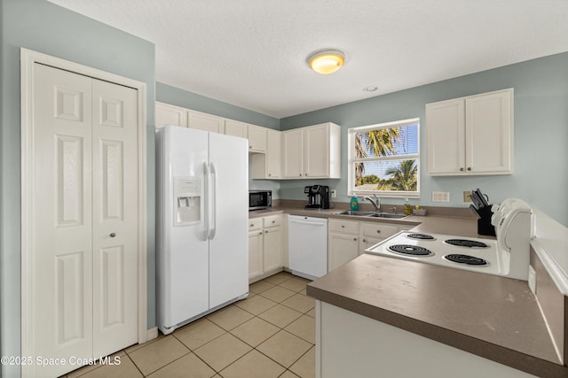 105 Ocean View Ln, Melbourne, FL 32903 - kitchen featuring white appliances, light tile patterned floors, white cabinets, a textured ceiling, and dark countertops