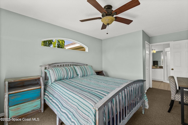 105 Ocean View Ln, Melbourne, FL 32903 - carpeted bedroom with ensuite bathroom, ceiling fan, and tile patterned floors