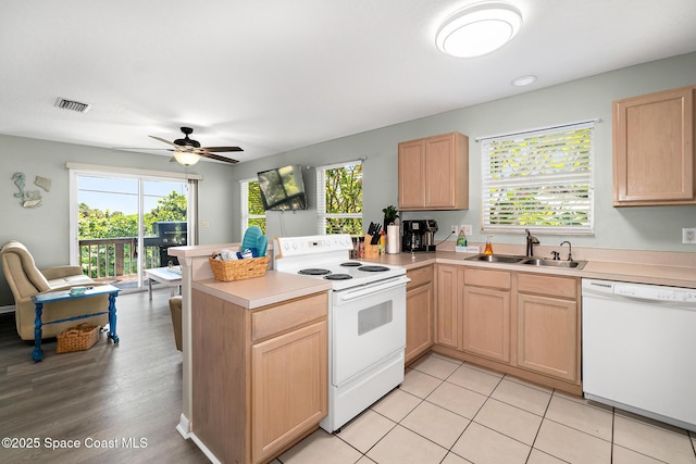105 Ocean View Ln, Melbourne, FL 32903 - kitchen featuring white appliances, a peninsula, light brown cabinets, and healthy amount of natural light