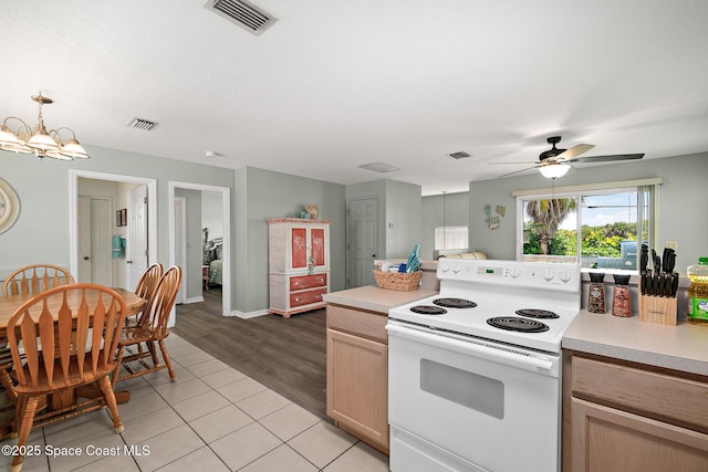 105 Ocean View Ln, Melbourne, FL 32903 - kitchen with white electric range oven, light countertops, a chandelier, a ceiling fan, and light tile patterned floors