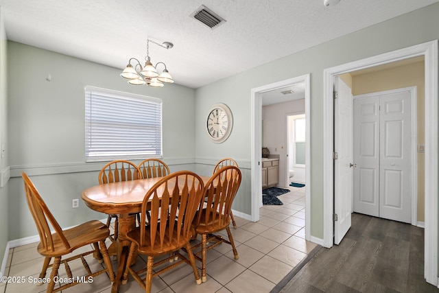 105 Ocean View Ln, Melbourne, FL 32903 - dining room with plenty of natural light, a chandelier, a textured ceiling, and light tile patterned floors