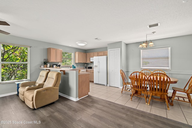 105 Ocean View Ln, Melbourne, FL 32903 - kitchen featuring white appliances, a peninsula, light countertops, light wood-style floors, and a chandelier