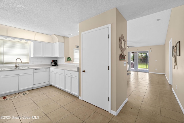 147 Ocean View Ln, Melbourne, FL 32903 - kitchen with dishwasher, light tile patterned floors, light countertops, a textured ceiling, and white cabinetry