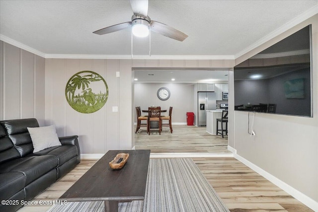 513 Ronnie Dr, Indian Harbour Beach, FL 32937 - living room featuring light wood-style floors, ornamental molding, ceiling fan, and a textured ceiling