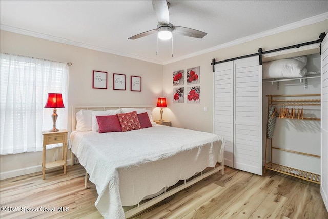 513 Ronnie Dr, Indian Harbour Beach, FL 32937 - bedroom with a barn door, crown molding, light wood-type flooring, a closet, and ceiling fan