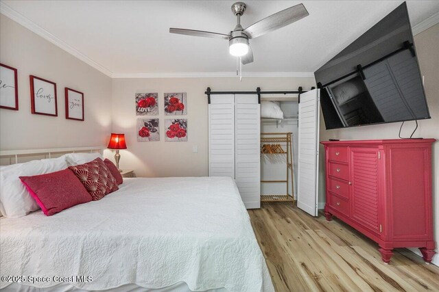 513 Ronnie Dr, Indian Harbour Beach, FL 32937 - bedroom featuring a barn door, crown molding, light wood finished floors, and a ceiling fan