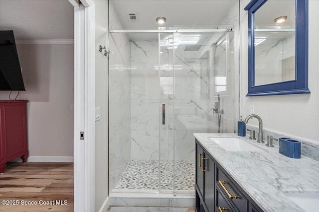 513 Ronnie Dr, Indian Harbour Beach, FL 32937 - full bathroom with double vanity, a marble finish shower, ornamental molding, and wood finished floors