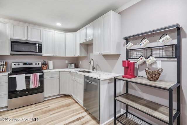 513 Ronnie Dr, Indian Harbour Beach, FL 32937 - kitchen featuring appliances with stainless steel finishes, light wood-style flooring, light stone counters, white cabinets, and recessed lighting