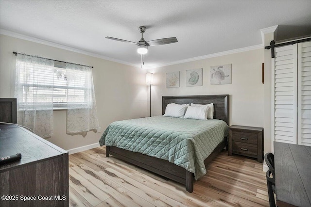 513 Ronnie Dr, Indian Harbour Beach, FL 32937 - bedroom with light wood finished floors, ornamental molding, a barn door, and ceiling fan