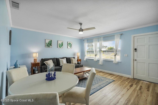 513 Ronnie Dr, Indian Harbour Beach, FL 32937 - dining space featuring light wood finished floors, ornamental molding, ceiling fan, and a textured ceiling
