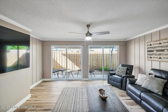 513 Ronnie Dr, Indian Harbour Beach, FL 32937 - living area featuring crown molding, healthy amount of natural light, light wood finished floors, a ceiling fan, and a textured ceiling
