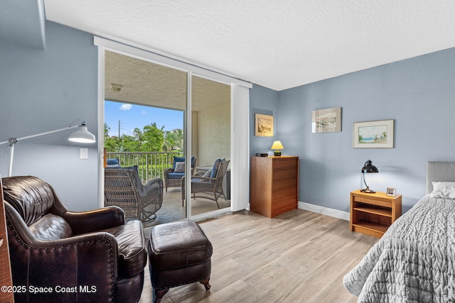 3360 S Atlantic Ave Unit 212, Cocoa Beach, FL 32931 - bedroom featuring access to exterior, wood finished floors, and a textured ceiling