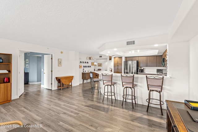 3360 S Atlantic Ave Unit 212, Cocoa Beach, FL 32931 - kitchen featuring appliances with stainless steel finishes, a breakfast bar area, a peninsula, light wood-type flooring, and light countertops