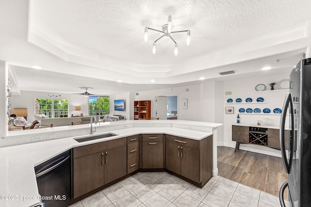 3360 S Atlantic Ave Unit 212, Cocoa Beach, FL 32931 - kitchen with appliances with stainless steel finishes, ceiling fan, a raised ceiling, dark brown cabinets, and light countertops