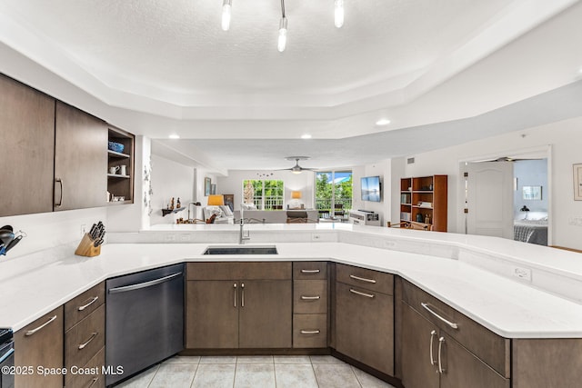 3360 S Atlantic Ave Unit 212, Cocoa Beach, FL 32931 - kitchen with stainless steel dishwasher, open floor plan, dark brown cabinets, light countertops, and a tray ceiling