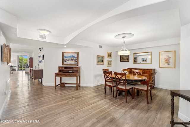 3360 S Atlantic Ave Unit 212, Cocoa Beach, FL 32931 - dining area with light wood-style flooring and arched walkways