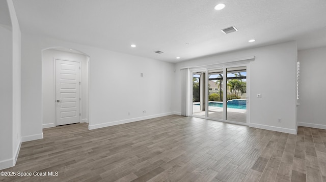 3110 Addison Dr, Melbourne, FL 32940 - empty room with wood finished floors, recessed lighting, and arched walkways