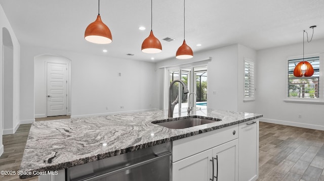 3110 Addison Dr, Melbourne, FL 32940 - kitchen featuring light wood-style floors, plenty of natural light, white cabinets, light stone countertops, and recessed lighting