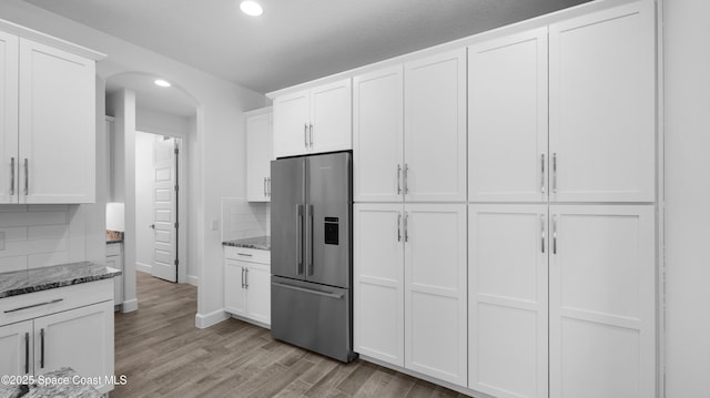 3110 Addison Dr, Melbourne, FL 32940 - kitchen with high end refrigerator, arched walkways, stone countertops, recessed lighting, and backsplash