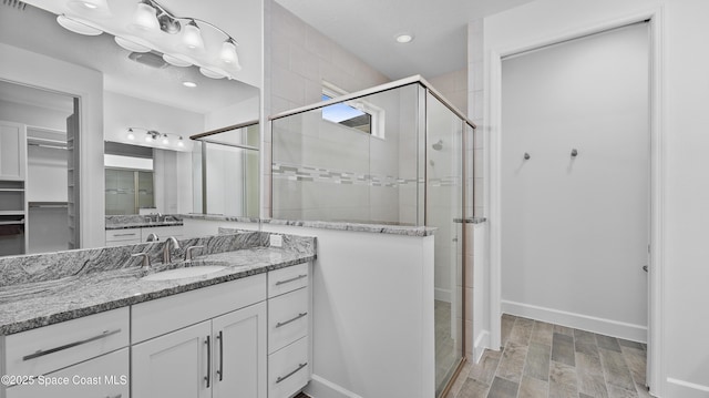 3110 Addison Dr, Melbourne, FL 32940 - full bathroom featuring a shower stall, vanity, wood finished floors, recessed lighting, and a spacious closet