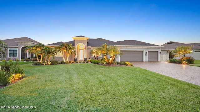3110 Addison Dr, Melbourne, FL 32940 - mediterranean / spanish-style house with an attached garage, decorative driveway, a front lawn, and stucco siding