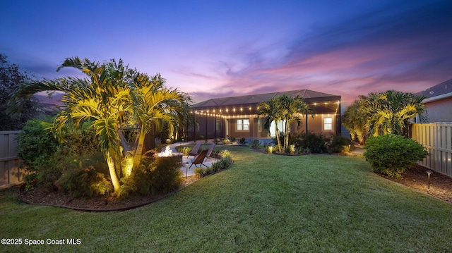 3110 Addison Dr, Melbourne, FL 32940 - yard at dusk with an outdoor fire pit, a fenced backyard, and a patio