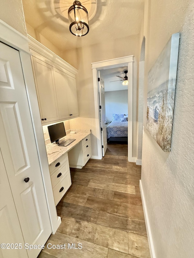 4569 Chastain Dr, Melbourne, FL 32940 - corridor with a textured wall, an office area, dark wood-style flooring, and a chandelier