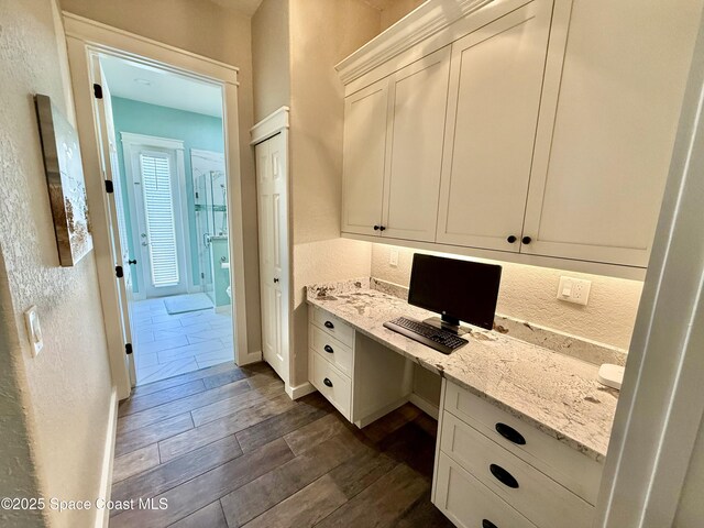4569 Chastain Dr, Melbourne, FL 32940 - unfurnished office with built in study area, dark wood-style floors, and a textured wall