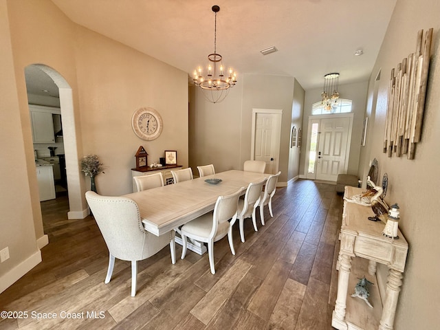 4569 Chastain Dr, Melbourne, FL 32940 - dining area with a chandelier, arched walkways, and dark wood-type flooring