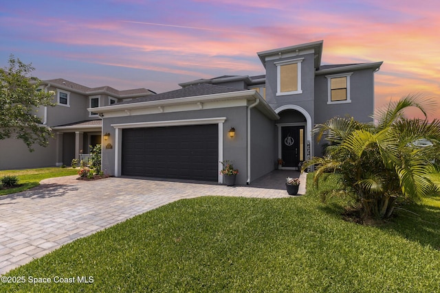 3243 Casare Dr, Melbourne, FL 32940 - view of front of home featuring a garage, a front lawn, stucco siding, and decorative driveway