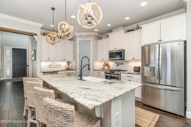 3243 Casare Dr, Melbourne, FL 32940 - kitchen featuring appliances with stainless steel finishes, a chandelier, crown molding, recessed lighting, and white cabinets