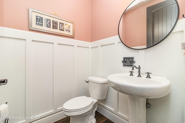 3243 Casare Dr, Melbourne, FL 32940 - half bathroom featuring wainscoting, a decorative wall, and wood finished floors