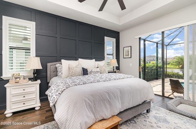 3243 Casare Dr, Melbourne, FL 32940 - bedroom featuring a decorative wall, access to exterior, dark wood finished floors, a water view, and a ceiling fan