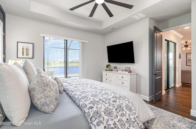 3243 Casare Dr, Melbourne, FL 32940 - bedroom featuring dark wood finished floors, a tray ceiling, and a ceiling fan