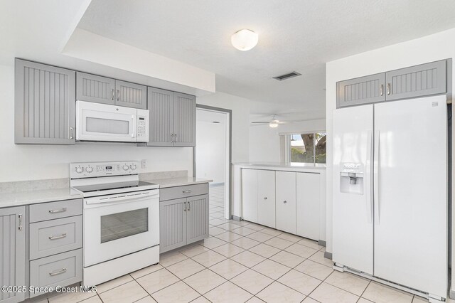 55 Yacht Haven Dr, Cocoa Beach, FL 32931 - kitchen featuring white appliances, gray cabinetry, light countertops, and ceiling fan