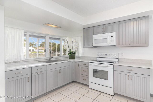 55 Yacht Haven Dr, Cocoa Beach, FL 32931 - kitchen featuring white appliances, gray cabinetry, and light countertops