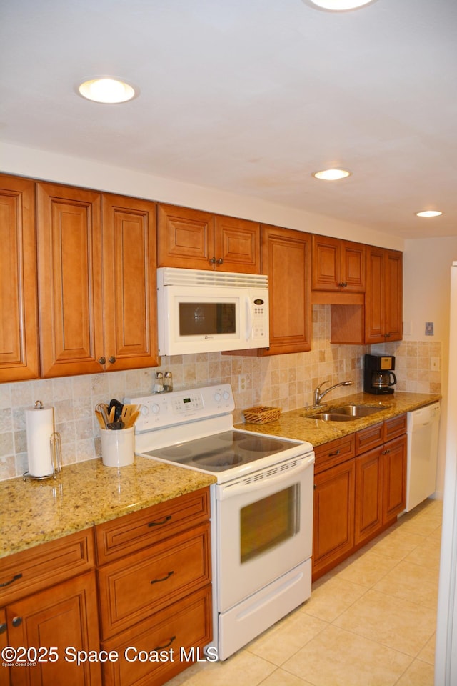 500 Palm Springs Blvd Unit 411, Indian Harbour Beach, FL 32937 - kitchen with white appliances, tasteful backsplash, and brown cabinets