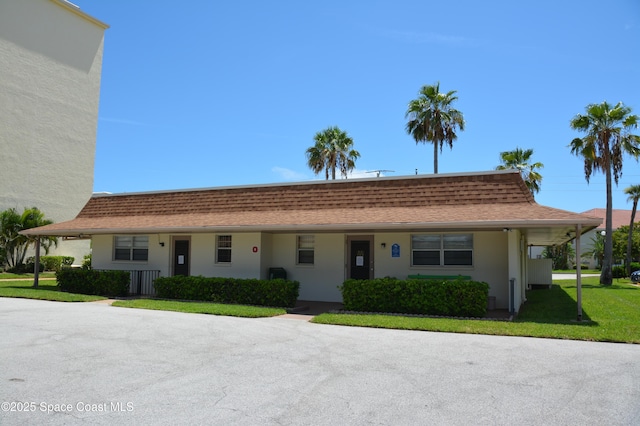 500 Palm Springs Blvd Unit 411, Indian Harbour Beach, FL 32937 - view of front of home featuring a front yard, roof with shingles, and stucco siding