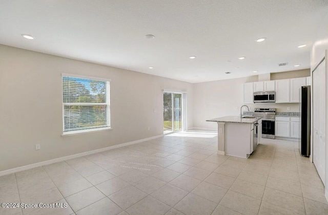 301 Latham St SE, Palm Bay, FL 32909 - kitchen featuring stainless steel appliances, open floor plan, white cabinets, recessed lighting, and light tile patterned floors