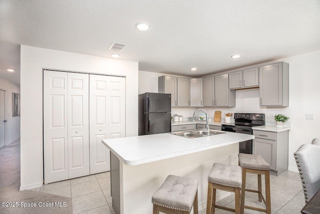 301 Latham St SE, Palm Bay, FL 32909 - kitchen with black appliances, gray cabinets, light tile patterned flooring, and recessed lighting