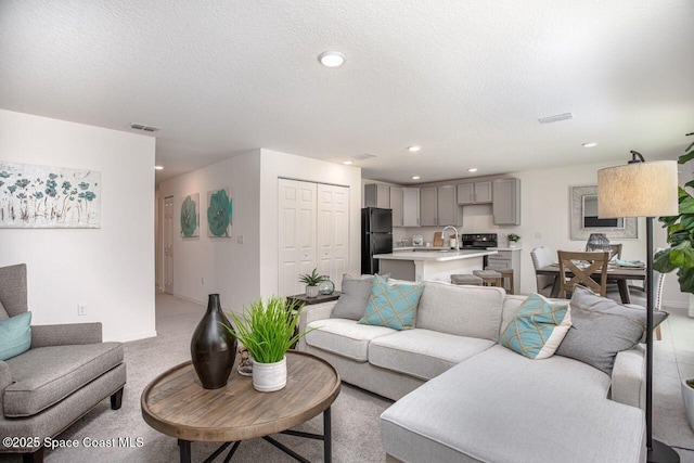 301 Latham St SE, Palm Bay, FL 32909 - living room featuring a textured ceiling, recessed lighting, and light colored carpet