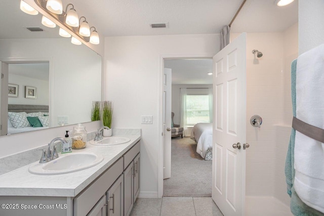 301 Latham St SE, Palm Bay, FL 32909 - ensuite bathroom featuring double vanity, tile patterned flooring, and a tile shower