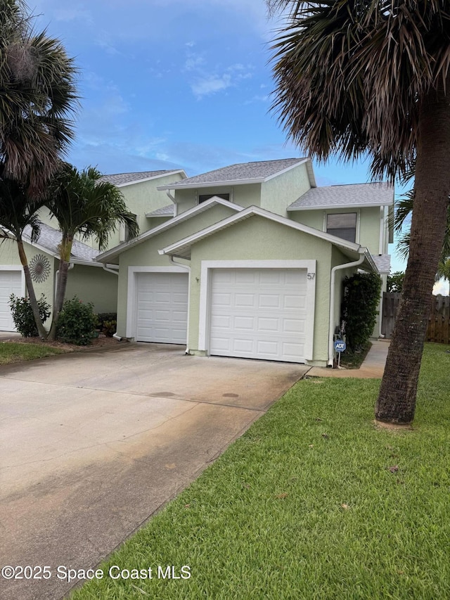 57 Anchor Dr, Indian Harbour Beach, FL 32937 - traditional-style house featuring stucco siding, concrete driveway, an attached garage, and a front lawn